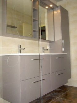 Meuble double vasque gris et blanc avec rangement en hauteur également.