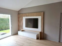 Création d'un meuble télévision avec panneau en bois pour réchauffer l'espace.