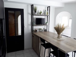 Table snack permettant de recevoir 4 ou 5 convives. Cuisine noire et bois, dans un style contemporain.